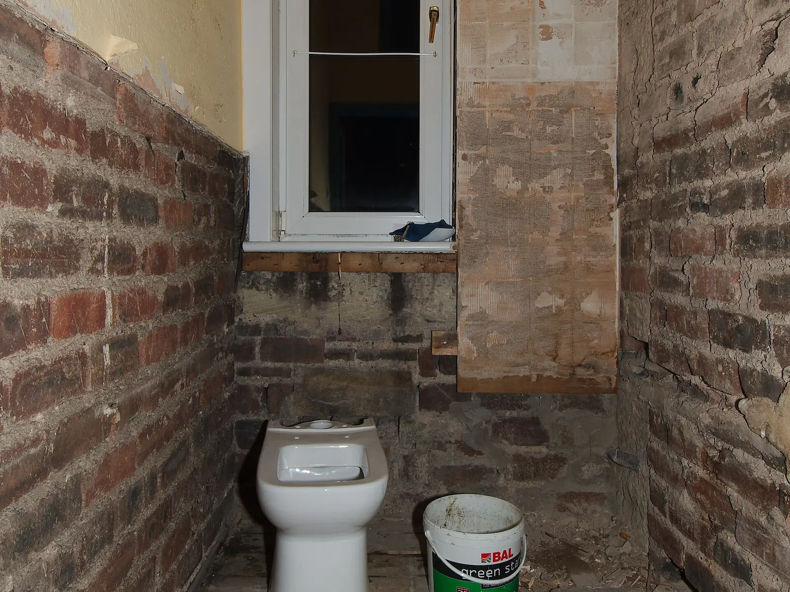 Antes: baño con revestimientos retirados y ladrillo a la vista